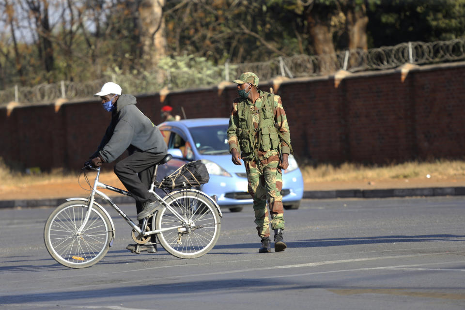 An armed soldier is seen on a street in Harare, Friday, July, 31, 2020. Zimbabwe's capital, Harare, was deserted Friday, as security agents vigorously enforced the country's lockdown amidst planned protests. Police and soldiers manned checkpoints and ordered people seeking to get into the city for work and other chores to return home. (AP Photo/Tsvangirayi Mukwazhi)