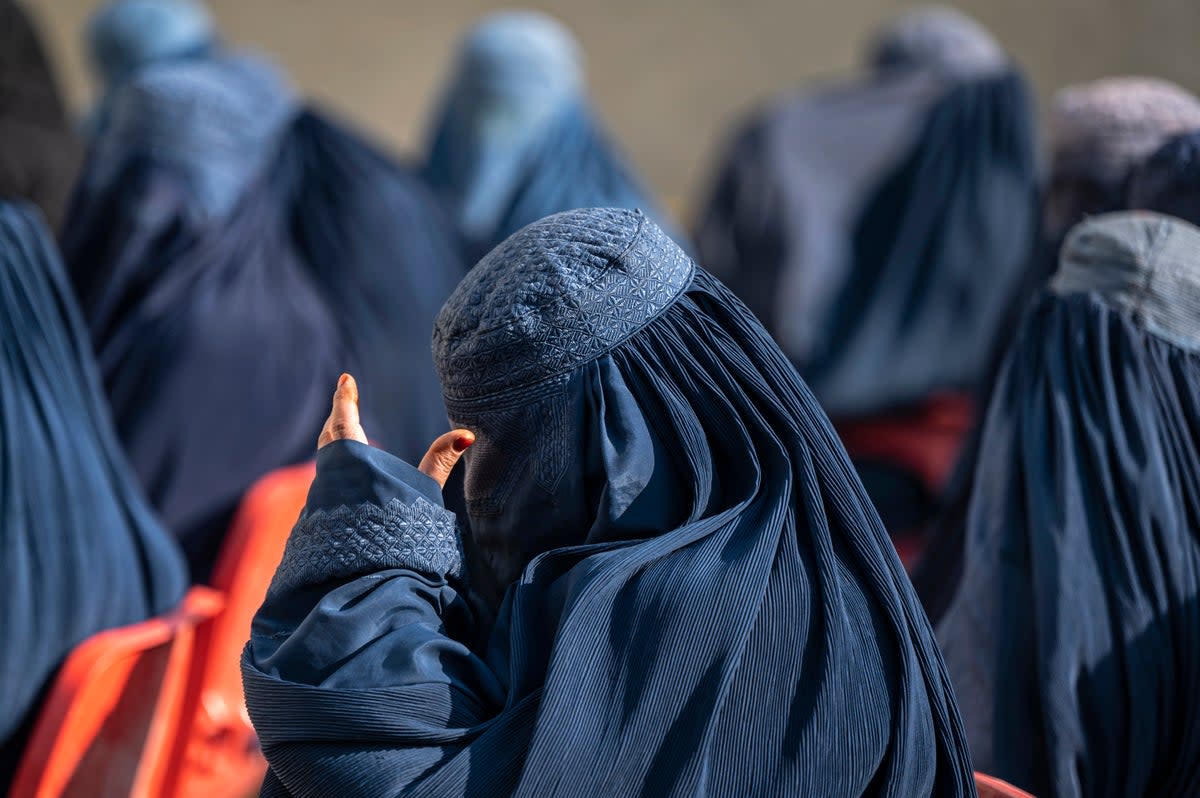Afghan burqa-clad women sit as they wait to receive cash money in Pul-i-Alam (AFP via Getty Images/ Representative image)