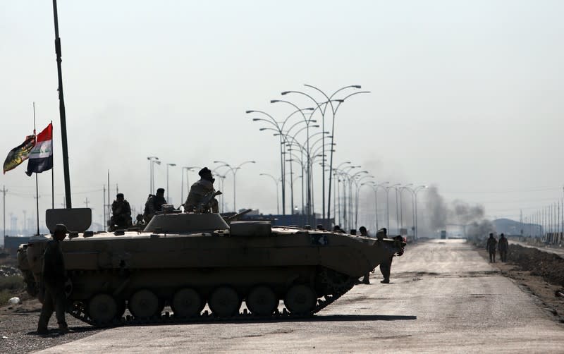 Iraqi army forces guards at the entrance of Umm Qasr Port as protesters block the road during ongoing anti-government protests, south of Basra