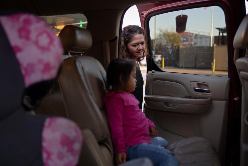 On November 3, 2023, Cristina Lazo, right, looks at her six-year-old daughter Alina in the backseat of their car in Houston, Texas.