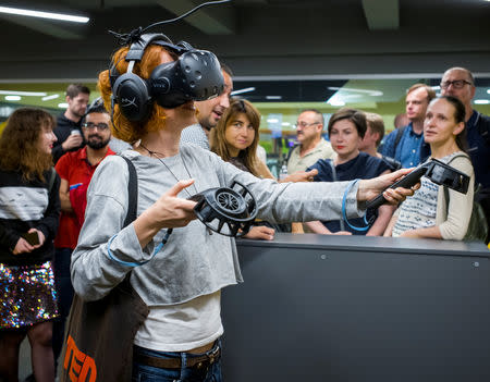 A visitor uses VR (Virtual Reality) glasses during the presentation of a simulator of virtual reality showing the 2013/2014 demonstration in Ukraine, when dozens of protesters were killed in the final moments of Viktor Yanukovich's rule, in Kiev, Ukraine September 12, 2018. Picture taken September 12, 2018. REUTERS/Gleb Garanich