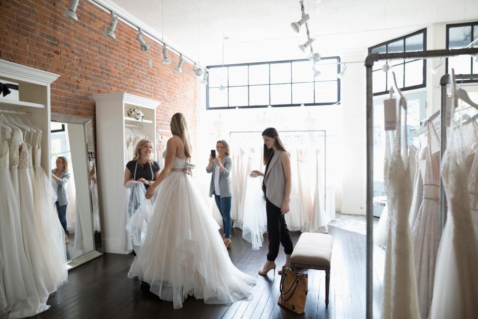 Woman Trying on Wedding Dress at Bridal Salon with Friends