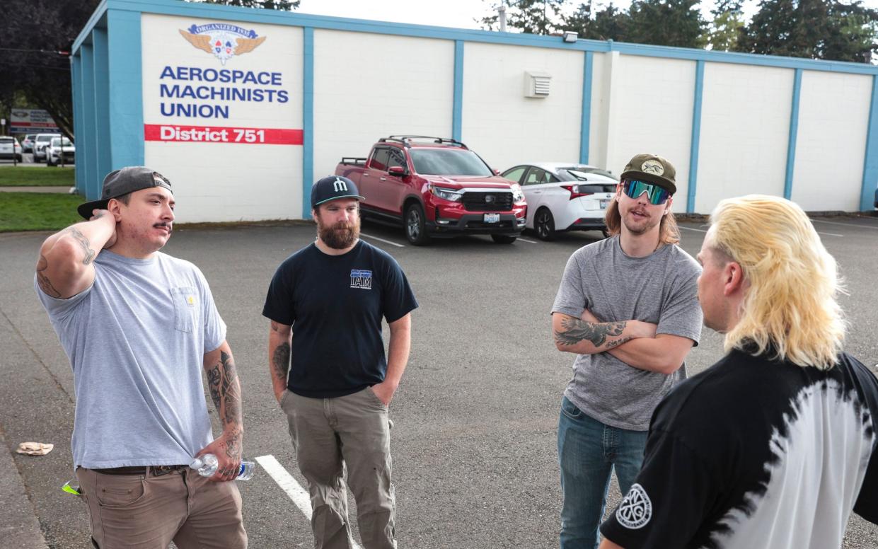 Boeing mechanic Joe Philbin, second from left, said his employer 'can survive paying the people who do the work a little more'