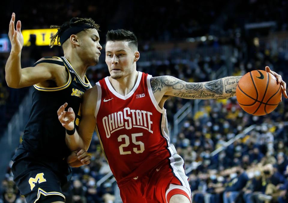 Ohio State forward Kyle Young (25) drives against Michigan forward Terrance Williams II (5) during the first half of an NCAA college basketball game Saturday, Feb. 12, 2022, in Ann Arbor, Mich. (AP Photo/Duane Burleson)