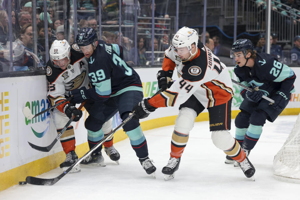 Anaheim Ducks left wing Ross Johnston (44) and right wing Jakob Silfverberg (33) go for the puck as Seattle Kraken center Ryan Winterton (26) and defenseman Ryker Evans (39) pursue during the second period of an NHL hockey game Thursday, March 28, 2024, in Seattle. (AP Photo/Jason Redmond)