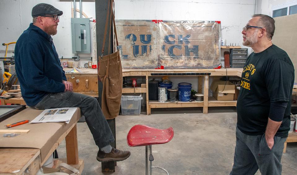 Duane Houghton, left, of Early American Restoration in Framingham, chats with Casey's Diner owner Pat Casey, inside Houghton's shop, April 2, 2024. The Natick diner's original painted exterior "Quick Lunch" panels were discovered during repairs after a car crashed into the diner. The old panels are believed to be the last original siding from any Worcester Lunch Car Co. diners made. Houghton is re-creating the panels and the etched glass windows.