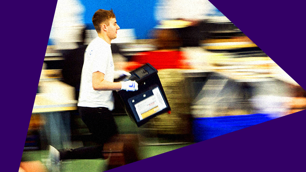 A volunteer runs with a ballot box for three constituencies in Tyne and Wear ceremonial county at the Silksworth Community Pool, Tennis and Wellness Centre in Sunderland on 8 June 2017