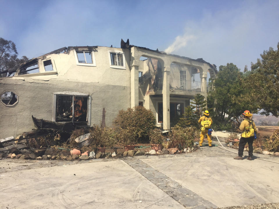 <p>Firefighters hose down the remains of a burned home in Sand Canyon area near Santa Clarita, Calif., July 24, 2016. (AP Photo/Matt Hartman)</p>