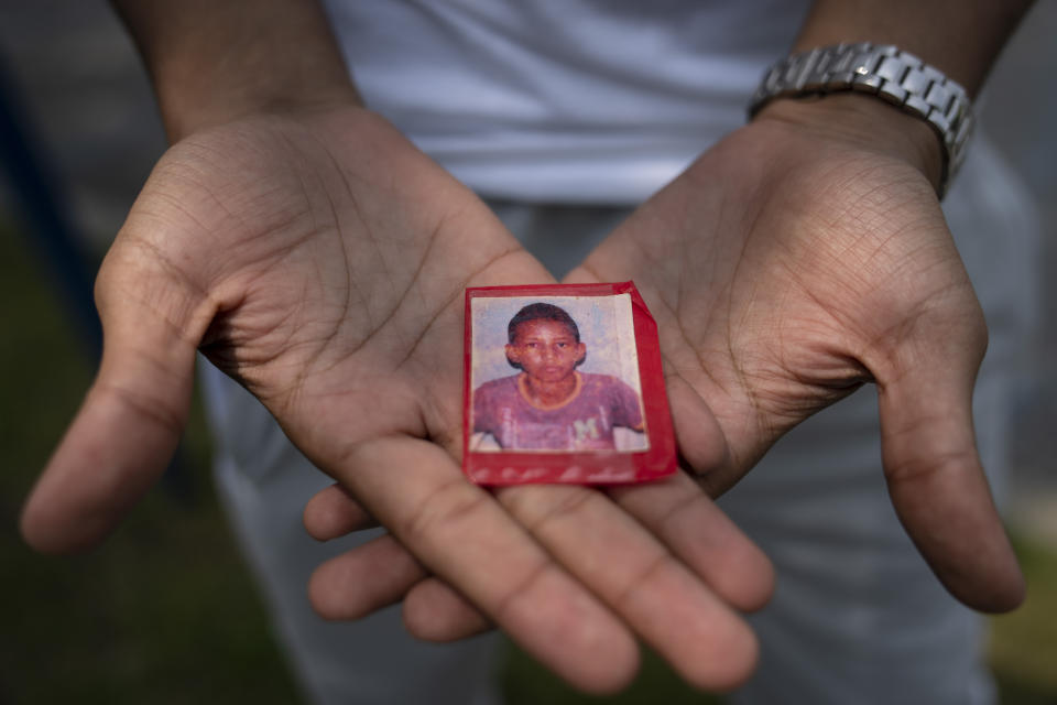 Mohamed, a 19-year-old fleeing political persecution in the northwest African country of Mauritania, holds a picture of himself as a child that his mother gave him as a momento before he departed for the United States, Monday, May 22, 2023, outside the Crossroads Hotel in Newburgh, N.Y. Mohamed is one of about 400 international migrants the city has been putting up in a small number of hotels in other parts of the state this month to relieve pressure on its overtaxed homeless shelter system and has become a pawn in an escalating stand-off between New York City and suburban and upstate communities, which are using lawsuits, emergency orders and political pressure to keep people like him out. (AP Photo/John Minchillo)