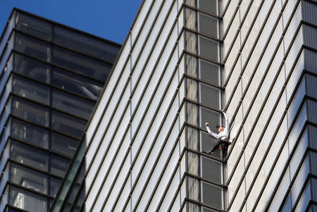 French free-climber Alain Robert, known as 'Spiderman', celebrates as he nears completing his attempt to climb up the outside of the Heron Tower in the financial district of London, Britain, October 25, 2018. REUTERS/Peter Nicholls