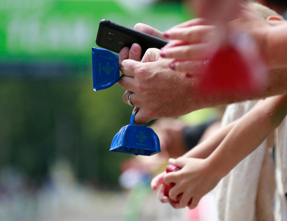 Spectators ring bells as they cheer for riders at the Pelotonia finish line at Kenyon College in Gambier in 2017.