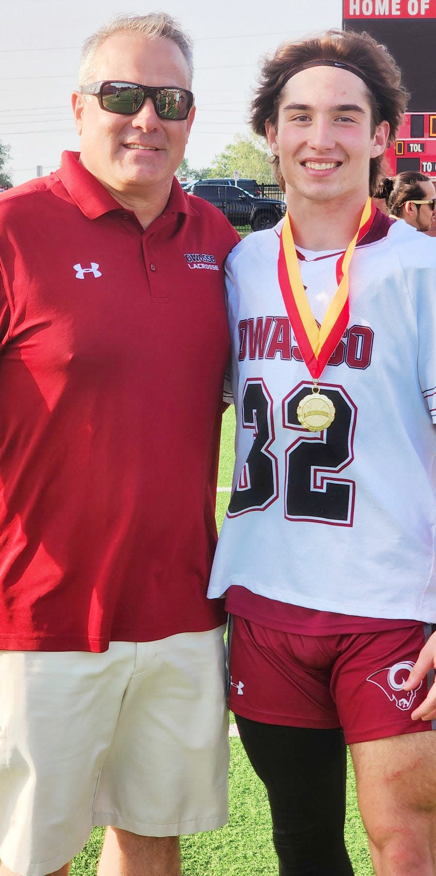 Ron McGill, left, poses with his son Duke McGill after McGill helped the Owasso Lacrosse Club team win the state title.