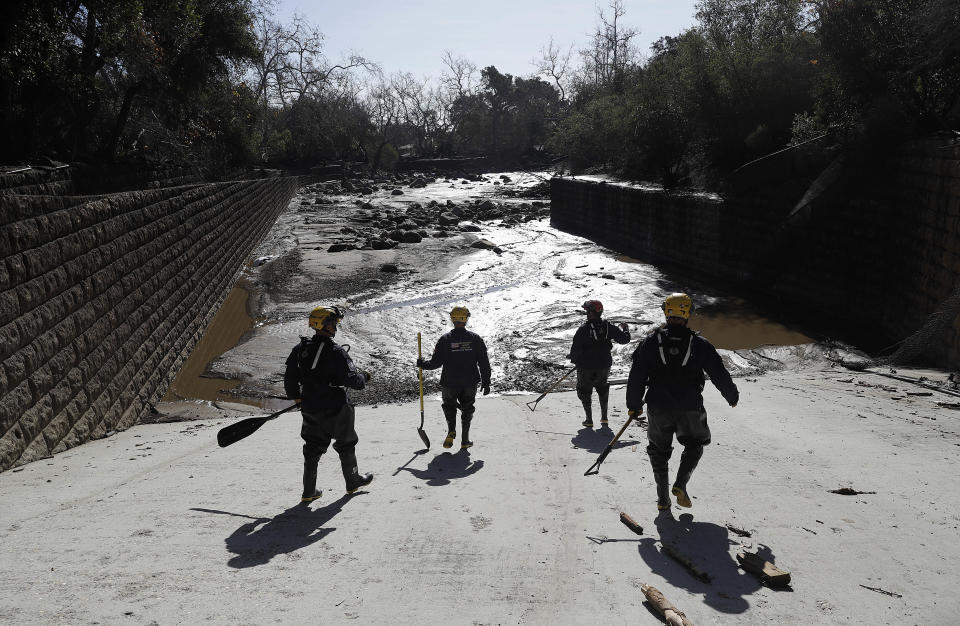 <p>Members of the Los Angeles County Fire Department Search and Rescue crew walk toward flooded waters in Montecito, Calif., Wednesday, Jan. 10, 2018. (Photo: Marcio Jose Sanchez/AP) </p>