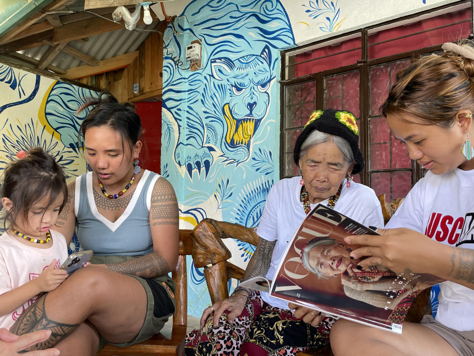 PRODUCTION - 24 May 2023, Philippines, Buscalan: Maria Oggay (2nd from right), known as Apo Whang-Od, the oldest mambabatok or traditional tattoo artist in the Philippines, looks on alongside great-niece Elyang Wigan (r), Grace Palicas (l), and her great-grandniece Zoey, at the Philippine edition of the internationally known magazine 