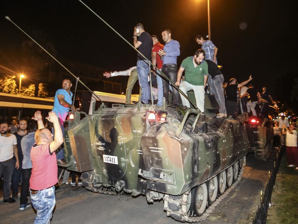 Turkish citizens, taking to the streets to react against a failed military coup attempt after Turkish President Recep Tayyip Erdogan called on people to defend democracy, on a tank as they intervene and block armoured vehicles of soldiers at Vatan street in Istanbul, Turkey in 2016.