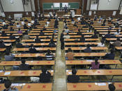 Test-takers keep social distancing as they wait for the start of a unified university entrance examination at a university in Tokyo Saturday, Jan. 16, 2021. The emergency decree now covers Tokyo and other 10 prefectures as the government seeks to stop a surge of new coronavirus infections. (Koki Sengoku/Kyodo News via AP)
