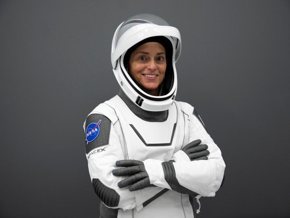 astronaut nicole mann poses smiling in white and grey spacex spacesuit against grey background