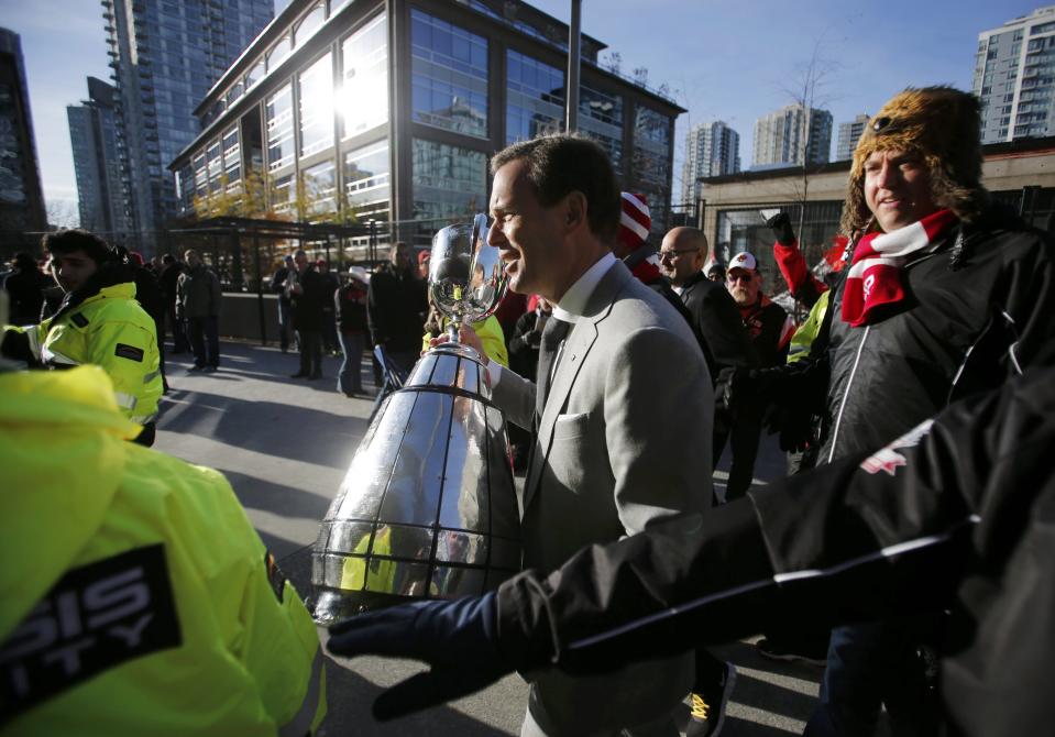 Outgoing CFL Commissioner Mark Cohon carries the Grey Cup ahead of the CFL's 102nd Grey Cup football championship between the Calgary Stampeders and the Hamilton Tiger Cats in Vancouver, British Columbia, November 30, 2014. REUTERS/Ben Nelms (CANADA - Tags: SPORT FOOTBALL)