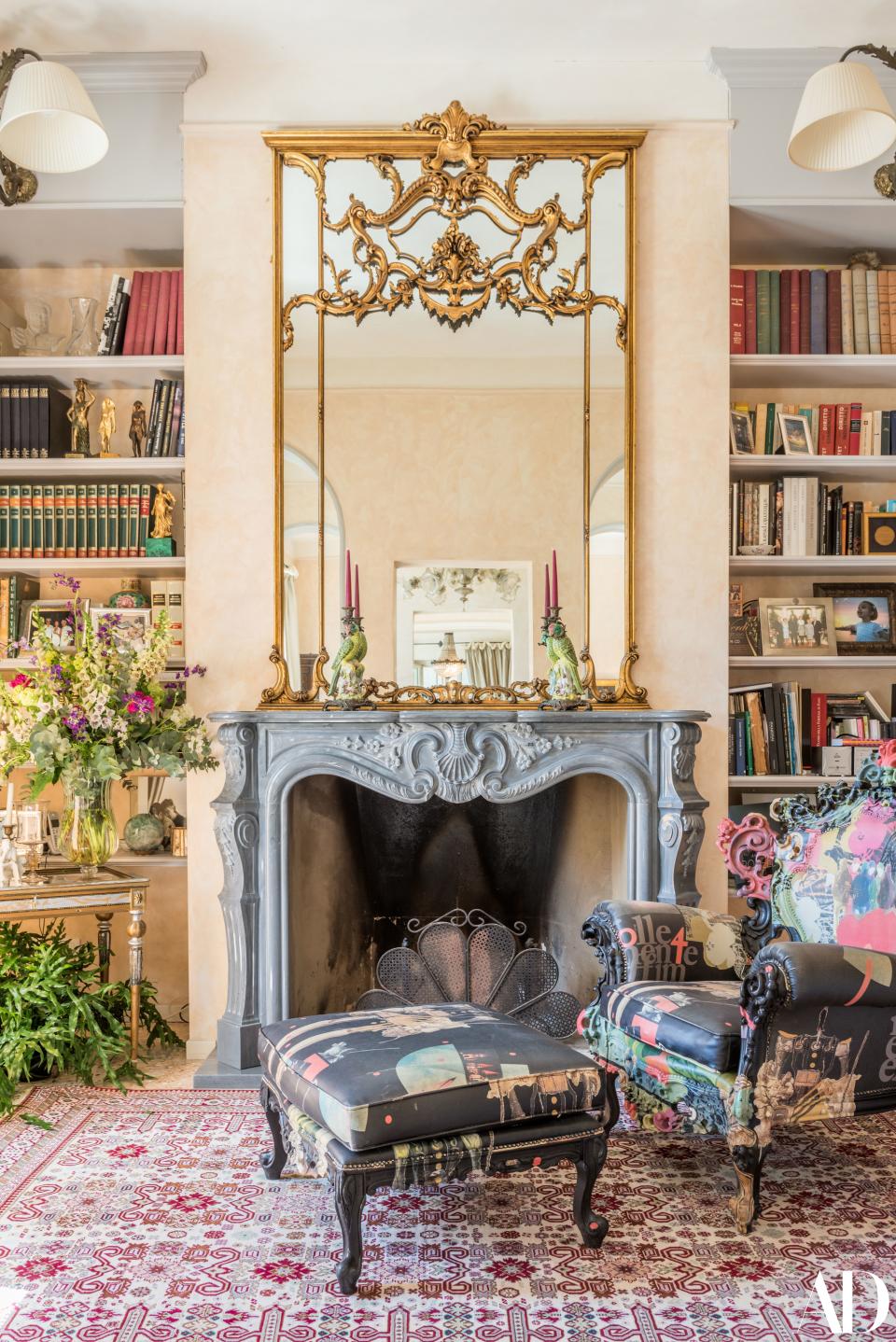 In one of the home’s living rooms, books on art, music, and literature fill the shelves. The brightly colored armchair and ottoman are “Follemente Effimero Opera” by Alberto Bartalini.