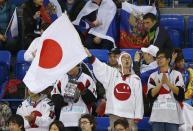 Fans, one waving a Japanese flag, attend the women's preliminary round ice hockey game between Japan and Germany at the Sochi 2014 Winter Olympic Games February 13, 2014. REUTERS/Jim Young (RUSSIA - Tags: SPORT ICE HOCKEY OLYMPICS)
