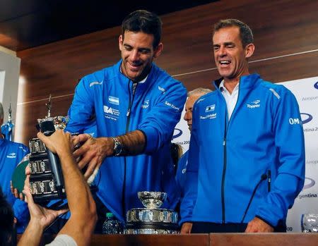 Juan Martin del Potro of Argentina's Davis Cup tennis team, holds a trophy next to captain Daniel Orsanic upon their arrival in Buenos Aires, Argentina, November 29, 2016. REUTERS/Agustin Marcarian