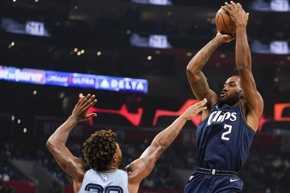 LA Clippers forward Kawhi Leonard, right, shoots against Memphis Grizzlies guard Marcus Smart during the first half of an NBA basketball game, Sunday, Nov. 12, 2023, in Los Angeles. (AP Photo/Ryan Sun)