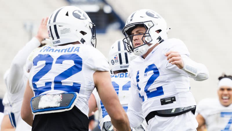 BYU Cougars quarterback Jake Retzlaff (12) celebrates with running back Mason Fakahua (22) during the annual BYU Blue vs. White scrimmage at LaVell Edwards Stadium in Provo on Friday, March 31, 2023.