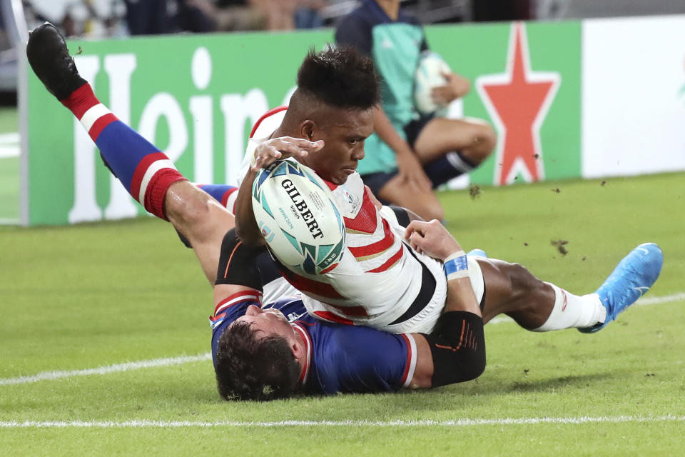 Japan's Kotaro Matsushima, top, makes an attempt to score a try, tackled by Russia's Vasily Artemyev during the Rugby World Cup Pool A game at Tokyo Stadium between Russia and Japan in Tokyo, Japan, Friday, Sept. 20, 2019. The try was disallowed by video referee.(AP Photo/Eugene Hoshiko)