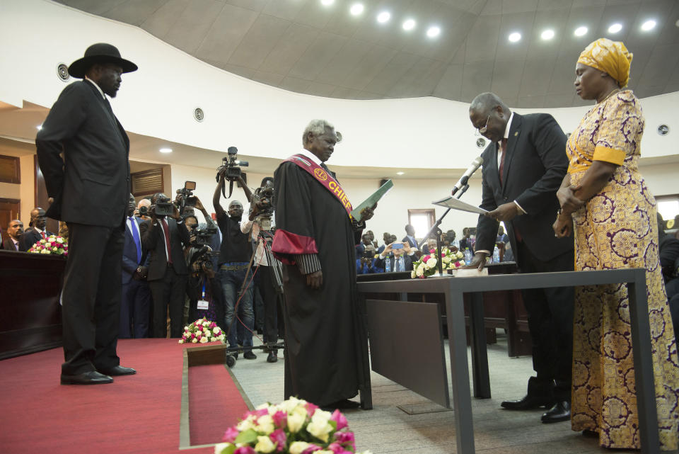 The president of South Sudan, Salva Kiir Mayardit, left, swears in Dr. Riek Machar as the first Vice President of South Sudan, in Juba, South Sudan Saturday, Feb. 22, 2020. South Sudan opened a new chapter in its fragile emergence from civil war Saturday as rival leaders formed a coalition government. (AP Photo/Charles Atiki Lomodong )