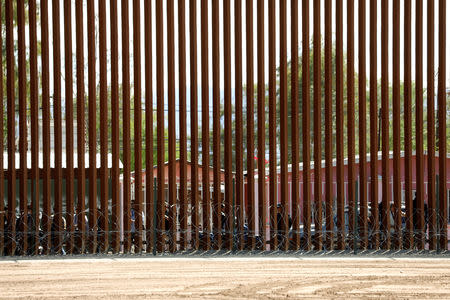FILE PHOTO - People stand on the other side of the fence in Mexico as President Donald Trump visits the U.S.-Mexico border in Calexico, California, U.S., April 5, 2019. REUTERS/Kevin Lamarque