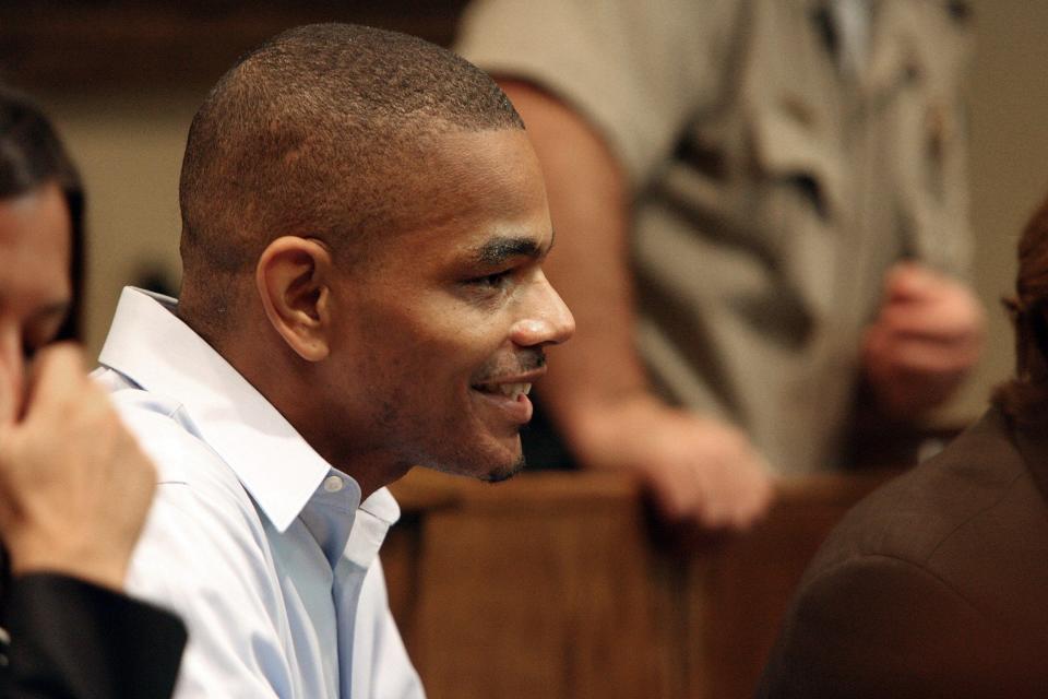 Jessie Dotson smiles while talking to members of his defense team as his murder trial continues in Judge James Beasley's courtroom on September 29, 2010.