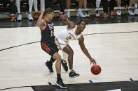 Texas' Marcus Carr (2) dribbles the ball around Texas Tech's Kevin McCullar (15) during the first half of an NCAA college basketball game on Tuesday, Feb. 1, 2022, in Lubbock, Texas. (AP Photo/Brad Tollefson)