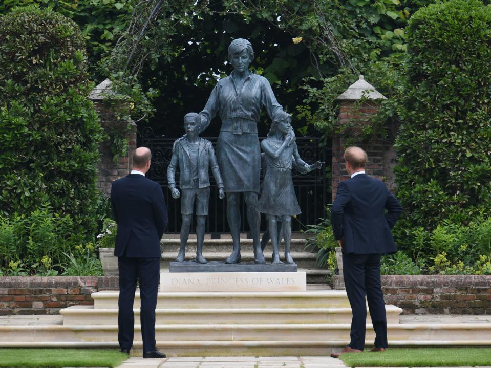 El duque de Cambridge (izquierda) y el duque de Sussex miran una estatua que encargaron a su madre Diana, la princesa de Gales, en el Sunken Garden en el Palacio de Kensington, Londres, en lo que habría sido su 60 cumpleaños. (PA)