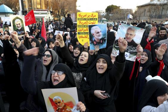 Chanting protesters outside the British embassy in Tehran hold up pictures of the general (AP)