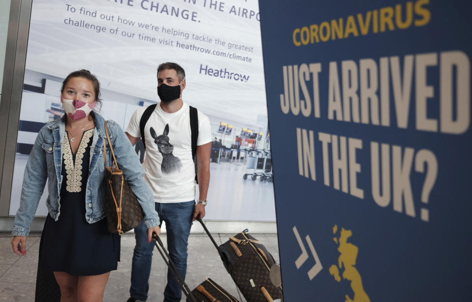 Passengers Charlotte and Frank, arrive at Heathrow Airport as they return from Mykonos in Greece, after the British Government added the island to the coronavirus quarantine list, at Heathrow, London, Tuesday Sept. 8, 2020.  From early Wednesday, people arriving from several Greek islands will need to self-isolate for 14-days, but mainland Greece will maintain its quarantine-exemption, according to Britain's Transport Secretary Grant Shapps, who said that England is to start applying a regional approach to its coronavirus quarantine policy.  (Yui Mok/PA via AP)