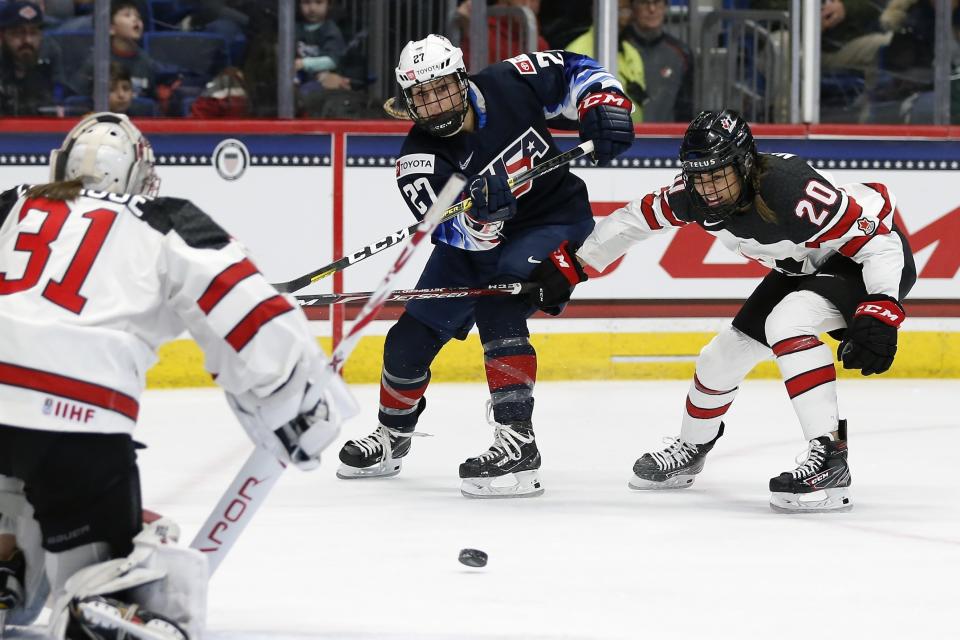 United States' Annie Pankowski (27) takes a shot on Canada's Geneviève Lacasse (31) as Sarah Nurse (20) defends during the first period of a rivalry series women's hockey game in Hartford, Conn., Saturday, Dec. 14, 2019. (AP Photo/Michael Dwyer)