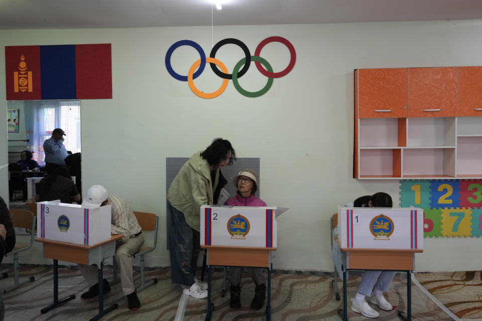 Mongolians prepare their votes at a polling station in Ulaanbaatar, Mongolia, Friday, June 28, 2024. Voters in Mongolia are electing a new parliament on Friday in their landlocked democracy that is squeezed between China and Russia, two much larger authoritarian states. (AP Photo/Ng Han Guan)