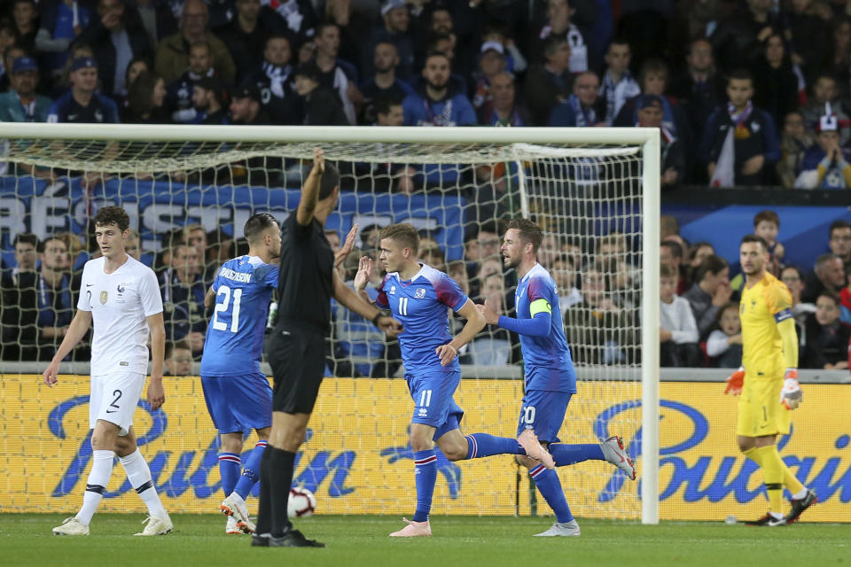 Iceland's Amor Ingvi Trautason, left, Alfred Finnbogason, center, and Gylfi Sigurdsson, celebrate after Iceland's Birkir Bjarnason, unseen, scored a goal during a friendly soccer match between France and Iceland, in Guingamp, western France, Thursday, Oct. 11, 2018. (AP Photo/David Vincent)