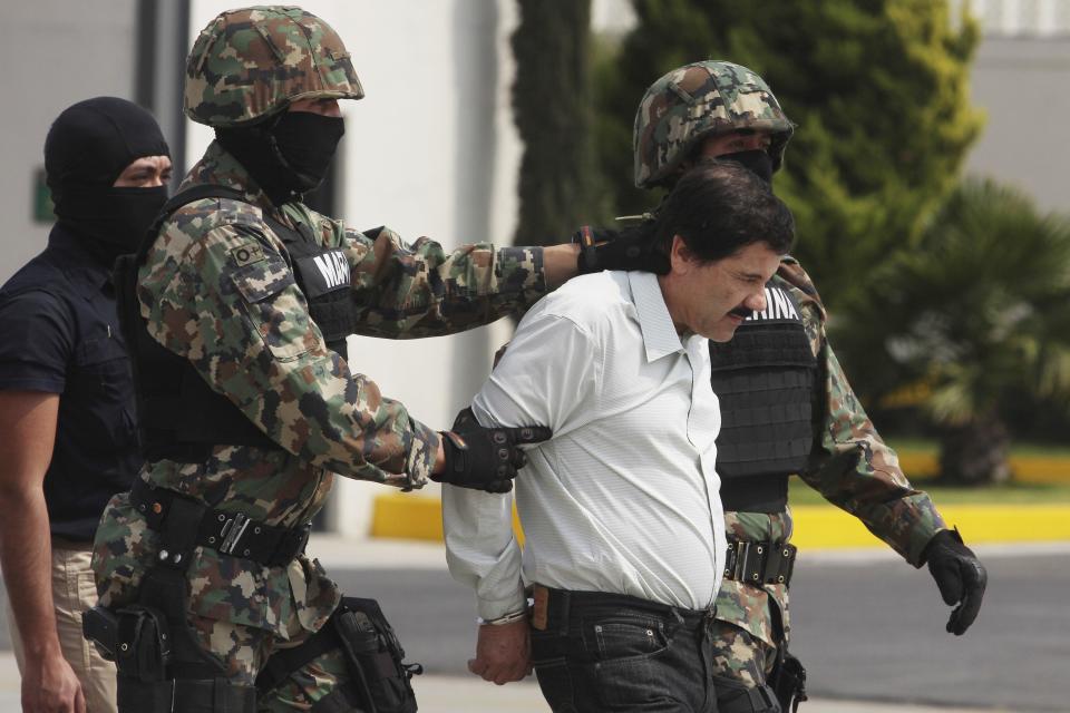  Joaquin 'El Chapo' Guzman is escorted to a helicopter in handcuffs by Mexican navy marines at a navy hanger.  / Credit: STR/LatinContent via Getty Images