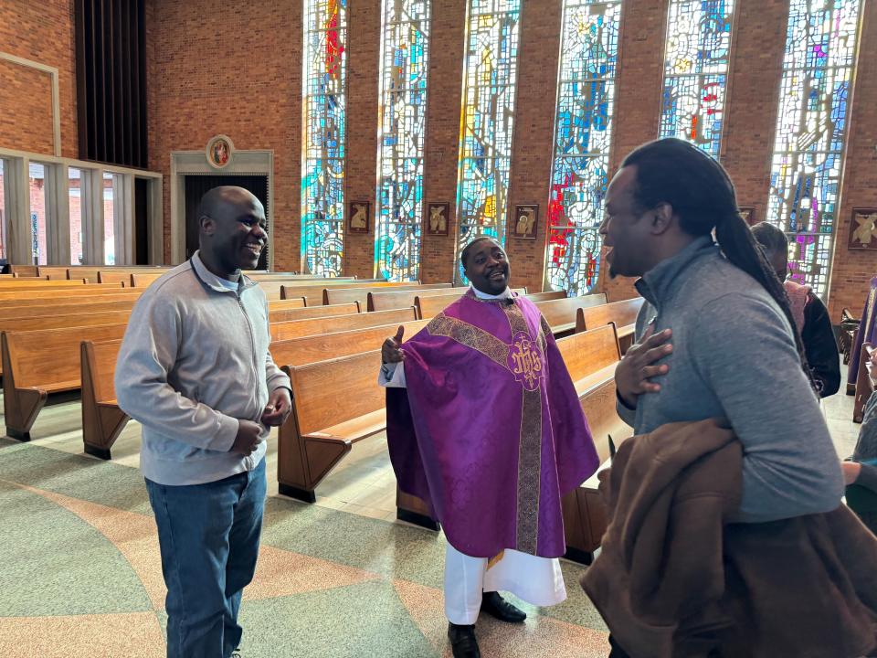 Cesar Badji, right, laughs with the Rev. Deogratias Fikiri and another parishioner after a French-language Mass at Holy Family Parish in Whitefish Bay. It was the first Mass in French in more than 20 years for Badji, who is from Senegal.