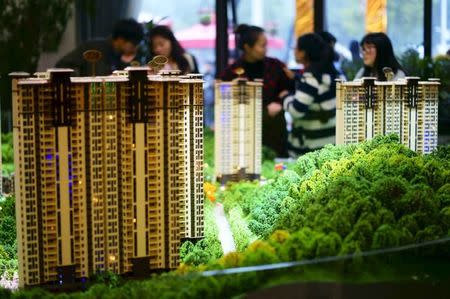 People look at miniature models of new apartments at a property sale centre in Yichang, Hubei province, November 21, 2015. REUTERS/Stringer/Files