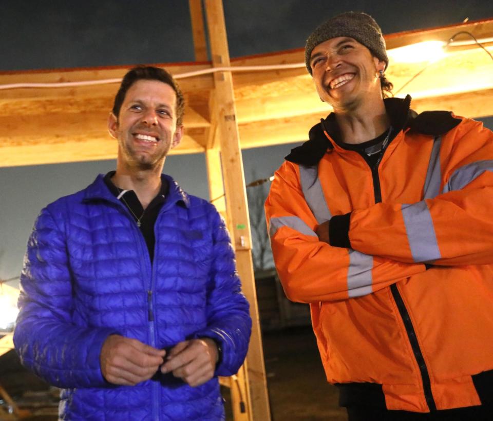 Yuval Sharon and Cannupa Hanska Luger in jackets smiling in the middle of an outdoor set