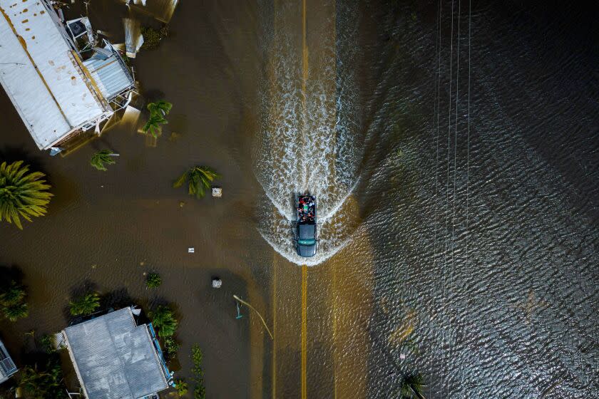 TOPSHOT - An aerial picture taken on September 29, 2022 shows a car driving through a flooded neighborhood in the aftermath of Hurricane Ian in Fort Myers, Florida. - Hurricane Ian left much of coastal southwest Florida in darkness early on Thursday, bringing "catastrophic" flooding that left officials readying a huge emergency response to a storm of rare intensity. The National Hurricane Center said the eye of the "extremely dangerous" hurricane made landfall just after 3:00 pm (1900 GMT) on the barrier island of Cayo Costa, west of the city of Fort Myers. (Photo by Ricardo ARDUENGO / AFP) (Photo by RICARDO ARDUENGO/AFP via Getty Images)