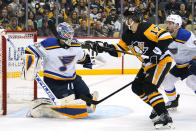 Pittsburgh Penguins' Bryan Rust (17) prepares to swat the puck into the net behind St. Louis Blues goaltender Jordan Binnington (50) for a goal during the second period of an NHL hockey game in Pittsburgh, Wednesday, Jan. 5, 2022. (AP Photo/Gene J. Puskar)