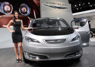 Model Tiffany Stone stands next to the Chrysler 700 C concept van as it is displayed on the final press preview day for the North American International Auto Show in Detroit, Michigan, January 10, 2012. REUTERS/Rebecca Cook