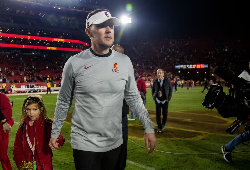 LOS ANGELES, CA - NOVEMBER 26, 2022: USC head coach Lincoln Riley holds his daughter's hand as he leaves the field after the Trojans beat Notre Dame at the Coliseum on November 26, 2022 in Los Angeles, California.(Gina Ferazzi / Los Angeles Times)