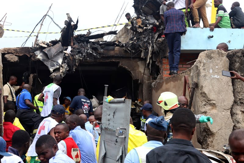 Rescuers and civilians gather at the accident scene of a plane Dornier 228-200 plane operated by local company Busy Bee that crashed into a densely populated neighborhood in Goma