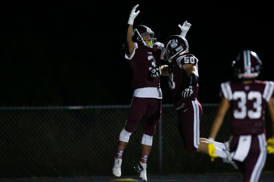 First Baptist Academy's Jordan Jean Luc (3) and First Baptist Academy's Tyler Fink (50) celebrate after a play during the Class 2A-Region 3 football Championship between FBA and Northside Christian on Friday, Nov. 26, 2021 at First Baptist Academy in Naples, Fla. 