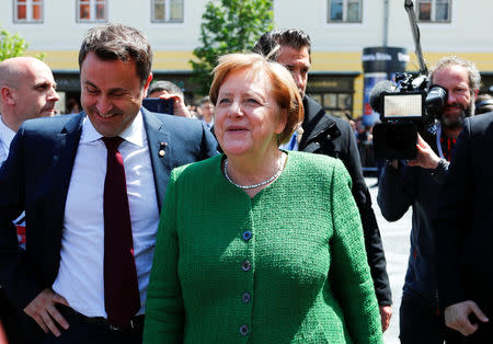 Luxembourg's Prime Minister Xavier Bettel and German Chancellor Angela Merkel react after the family photo opportunity during the informal meeting of European Union leaders in Sibiu, Romania, May 9, 2019. REUTERS/Francois Lenoir