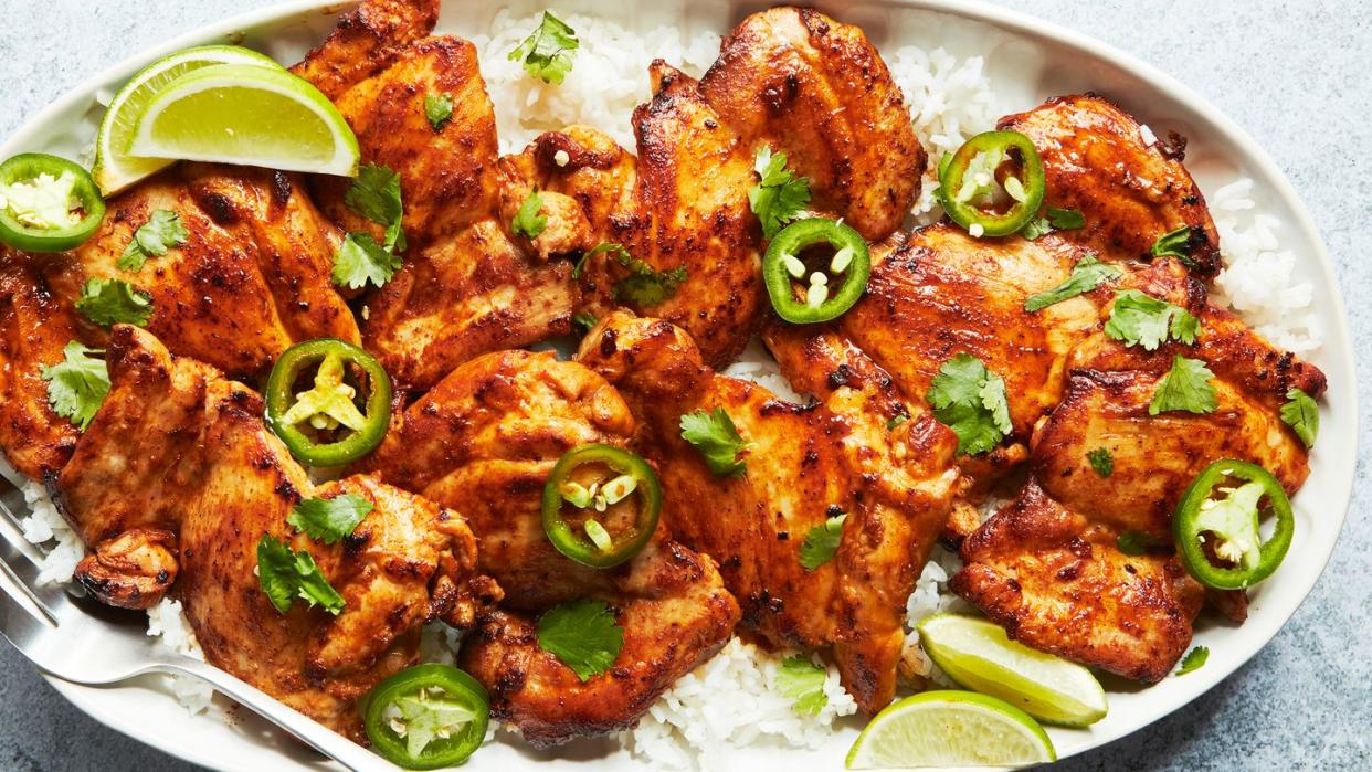 baked chicken thighs with lime wedges and jalapeno slices